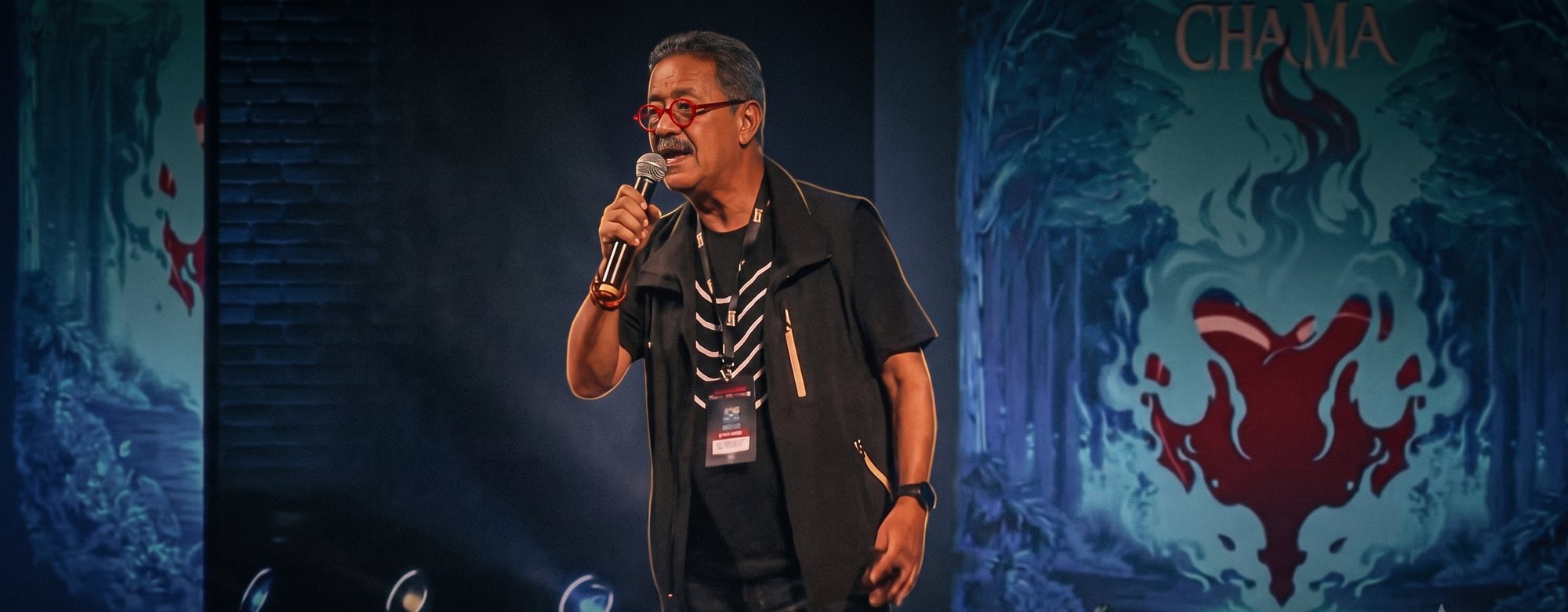 Toninho da Galeria durante uma palestra, ao microfone no palco